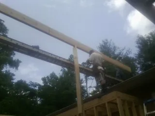 Carpenter setting a ridge beam over a new addition frame — Ice Dam Removal by Roofing Brothers in Blanchester