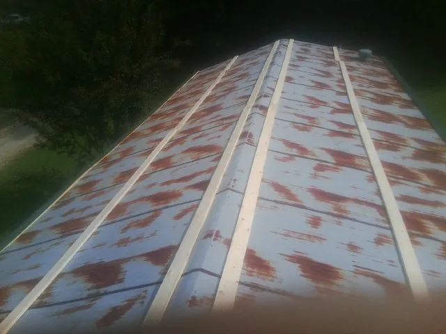 Rusted metal roof panels with new wood purlins before replacement — Storm Damage Roof Repair in Blanchester by Roofing Brothers