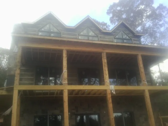 Dormers and porch framing on a large log home under construction — Roof Coating work by our crew in Blanchester
