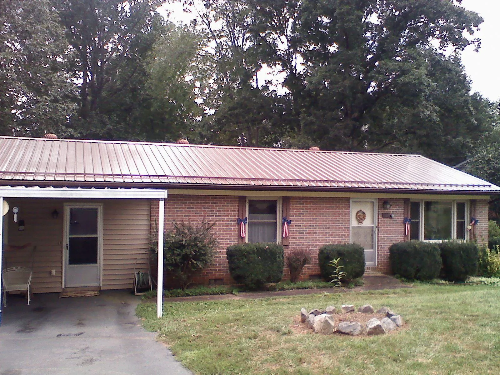 Bronze metal roof and carport on a brick ranch home — Roof Repair work by our crew in Blanchester